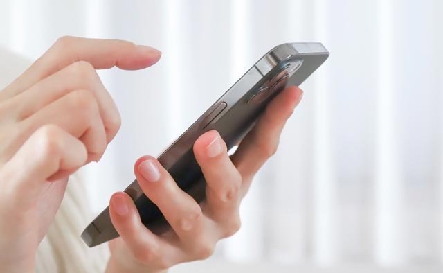 家族葬の多摩市葬儀社に電話でお問合せしようとしている人の手元。